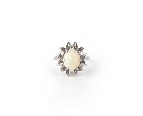 An opal and diamond ring, set with a cabochon opal, within a border of leaves accented with single-cut diamonds, mounted in w