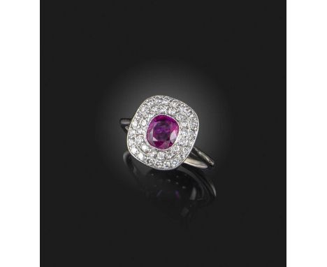 A ruby and diamond cluster ring, set with a cushion-shaped ruby weighing approximately 0.80 carats, within a double border of