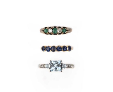 A collection of three rings, comprising: a five-stone ring set with circular-cut diamonds and step-cut emeralds, mounted in g