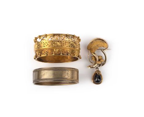 Two Victorian bangles and a garnet brooch, comprising: a hinged gold bangle, the front of scrolled openwork design, the inter