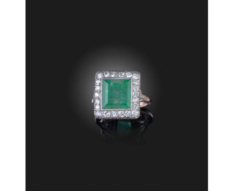 An emerald and diamond ring, set with a step-cut emerald within a border of single-cut diamonds, mounted in gold, size O1/2