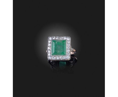 An emerald and diamond ring, set with a step-cut emerald within a border of single-cut diamonds, mounted in gold, size O1/2