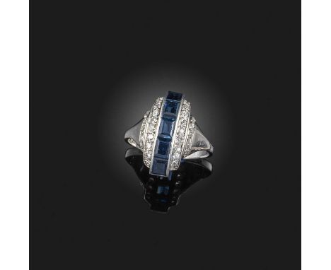 An Art Deco sapphire and diamond ring, 1930s, of domed design, centring on a line of calibré-cut sapphires, to stepped should