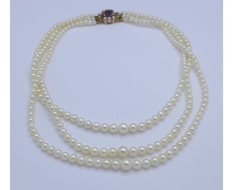 A triple row pearl necklace with amethyst and pearl set 9ct gold clasp