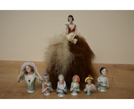 Seven vintage porcelain half doll pin cushions including two 1920's style one being complete with ostrich feather skirt.