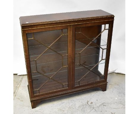 A reproduction mahogany display cabinet, the moulded top above a pair of astragal glazed doors, raised on bracket feet, 112 x