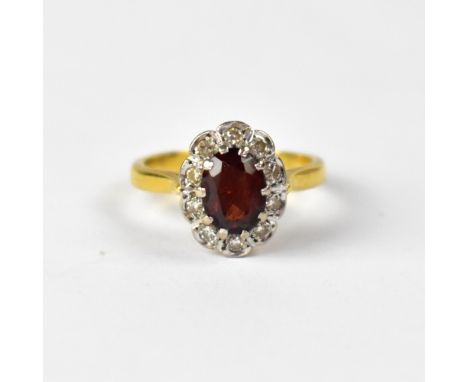 An 18ct yellow gold dress ring, floral set with oval ruby and small diamond surround, size L, approx 4.7g.