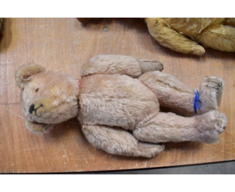 An early 20th century pale gold teddy bear in the style of Steiff, with button eyes, embroidered nose and paws, with pad feet