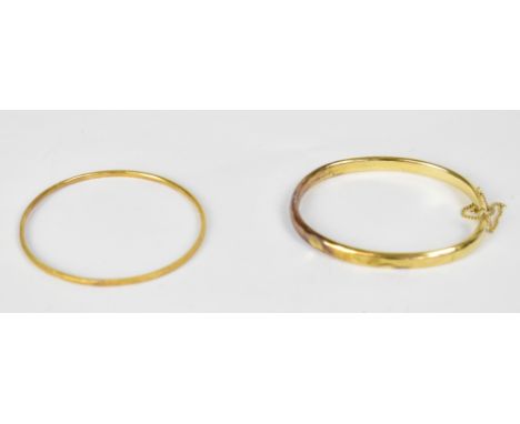 Two yellow metal bangles, one with clasp and safety chain, the other a continuous bangle with bead rim (2).
