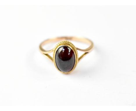 A 9ct gold dress ring with red oval cabochon in oval bezel mount, size P, approx 2.7g.