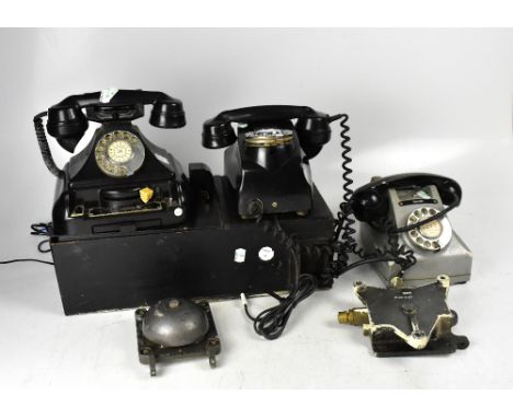 A mid-20th century black telephone kiosk coin box with buttons 'A' and 'B' and a white cast iron telephone, 'Flame Proof Tele