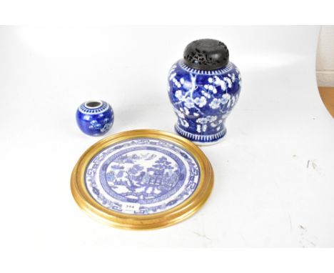 A large blue and white temple jar with carved and pierced wooden cover, the bulbous shaped body with prunus decoration, four 