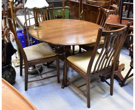 ERCOL; a circular oak dining table to turned and quadripartite support, when extended 120cm, and a set of six matching curved