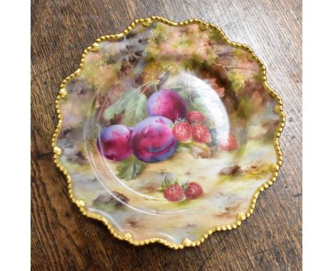 FRANK ROBERTS FOR ROYAL WORCESTER; a hand painted cabinet plate depicting plums and strawberries, with gilt-heightened beaded