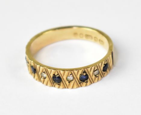 A 1970s 9ct yellow gold half eternity ring set with five blue stones and four white stones, on a 9ct yellow gold shank, size 