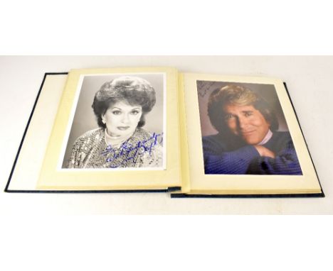 A blue album containing lobby and fan cards, bearing autographs of Music, TV and Film stars to include Timothy Dalton, Kirk D