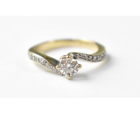 A white gold ring, the principal claw set diamond approx 0.33ct, on crossover shoulders, each with tiny pavé set brilliant cu