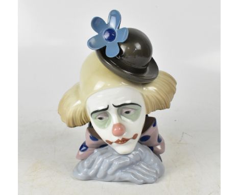 LLADRÓ; a ceramic head and shoulders bust of a clown with a blue flower in his hat, height 27cm.