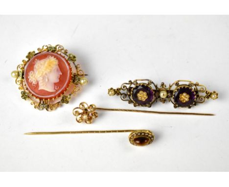 A group of Victorian and Edwardian yellow metal brooches to include a stick pin floral set with seed pearls, a stick pin with