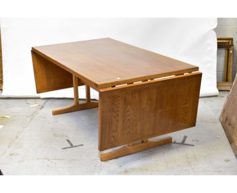 An early 20th century large oak drop-leaf table, cleated plank top set with drop leaves to the narrow end of the table, raise