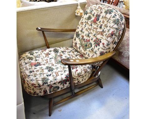 ERCOL; a retro stained teak low comb back open arm lounge chair.