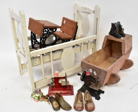 A scratch-built dolls' wooden cradle with hood, an early 20th century Singer-style children's sewing machine, a pair of brown