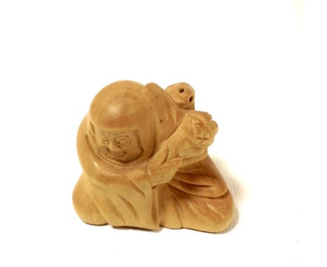 A signed carved wooden netsuke of Bodhidharma with a rat upon his shoulder. H4cm.