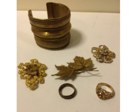 Six items of vintage costume jewellery. Three brooches, one stamped Exquisite, a tribal bangle and two rings. (6)