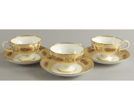 Three Victorian porcelain cups and saucers, each decorated with flowers within elaborate gilt borders