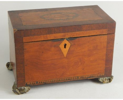 A George III mahogany inlaid and amboyna tea caddy, of rectangular outline, the hinged lid revealing a plain interior on comp