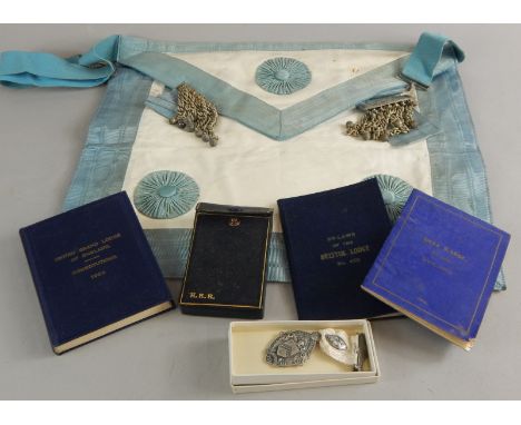 A Masonic apron, a silver jewelled Masonic jewel by Spencer & Co, Bristol Lodge rules, by laws, etc.