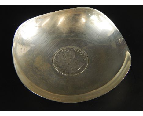 An Indian white metal small pin tray, inset with a George V one rupee, dated 1919, stamped sterling silver, 2oz, 9.5cm wide.