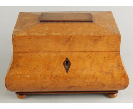 A bombe sarcophagus shaped burr elm tea caddy, the hinged lid revealing a sectional interior set with ivory knops, with a sha