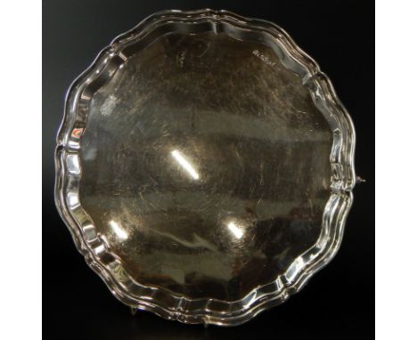 An Elizabeth II silver salver, with a raised pie crust type border on shaped skull carved feet, Sheffield 1964, 25½oz, 32cm d