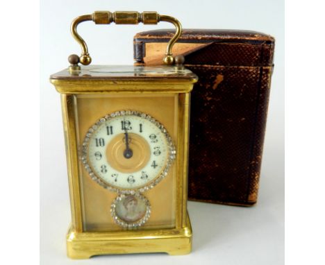 A late 19th/early 20thC French brass carriage clock, with a circular paste set and enamel dial above a similar aperture of a 