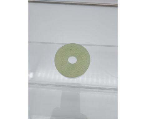 A Chinese hand carved jade disc [5.5cm in diameter] 