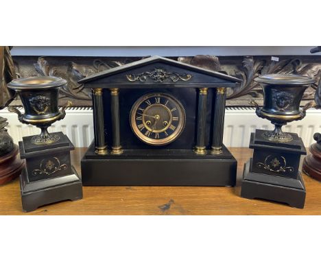 A 19th century French slate mantle clock with two matching garnitures. 