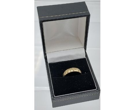 A 9ct gold engraved wedding band. [Ring size M] [weighs 1.81grams] 