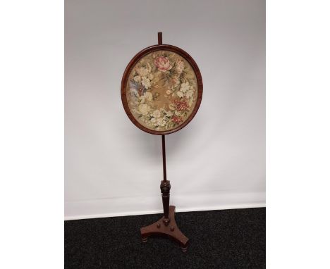 A 19th century pole screen with a round tapestry panel, supported upon a tripod base [149cm] 