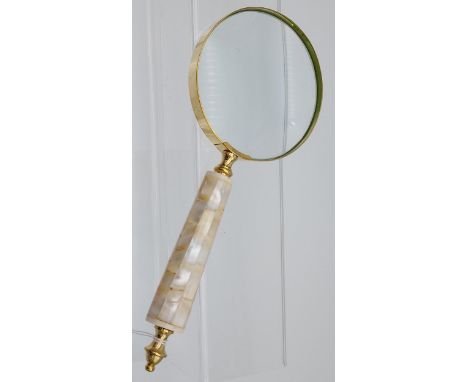A large hand held magnifying glass with mother of pearl handle 