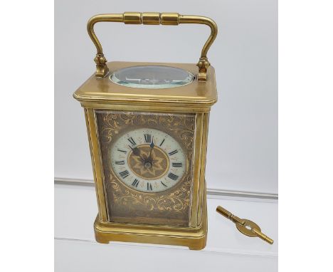 Antique Brass cased and bevel glass carriage clock. Designed with an enamel dial. In a working condition and comes with a key