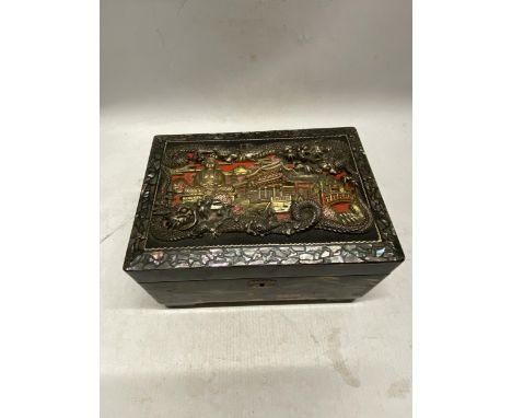 A VINTAGE LACQUERED ORIENTAL HAND PAINTED JEWELLERY BOX WITH RAISED RELIEF DETAIL AND INLAID MOTHER OF PEARL TO THE TOP 21.5 