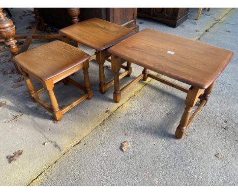 AN ERCOL ELM NEST OF THREE TABLES