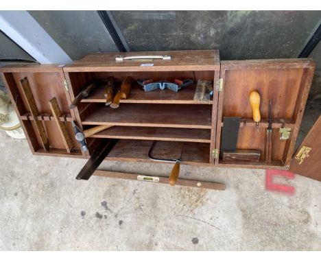 A TEAK JOINERS CHEST WITH AN ASSORTMENT OF TOOLS TO INCLUDE WOOD PLANES, A HAMMER AND A SAW ETC