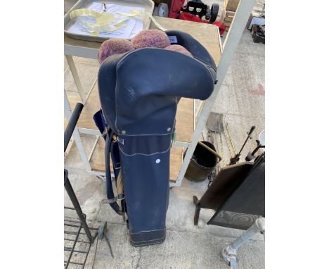 A VINTAGE GOLF BAG WITH AN ASSORTMENT OF GOLF CLUBVS
