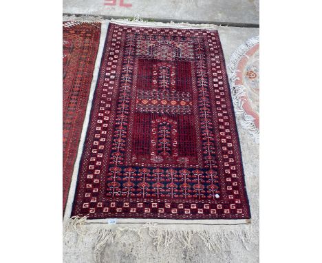 A VINTAGE RED PATTERNED FRINGED RUG