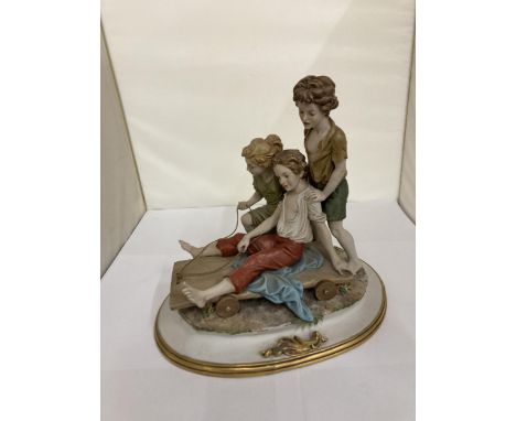 A CAPODIMONTE STYLE FIGURE GROUP OF CHILDREN PLAYING ON A CART