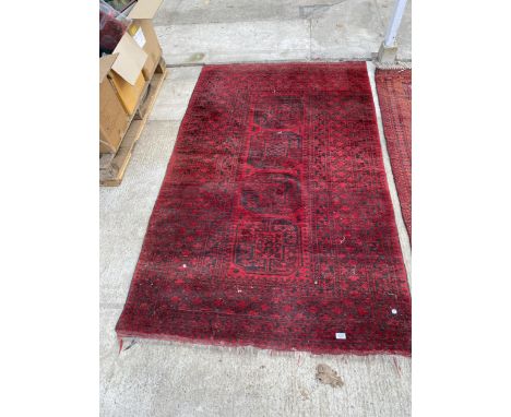 A VINTAGE RED PATTERNED FRINGED RUG