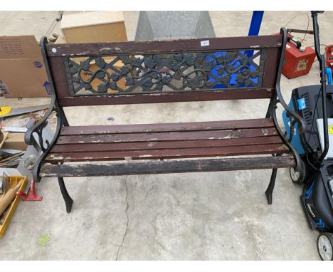 A WOODEN SLATTED GARDEN BENCH WITH CAST ENDS AND FLORAL CAST BACK