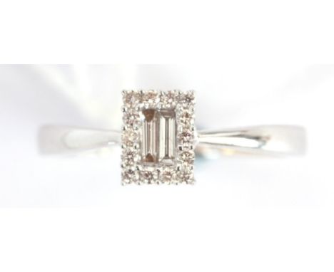 AN 18K WHITE GOLD DIAMOND RING having a rectangular frame set with brilliant cut diamonds surrounding two baguette cut diamon